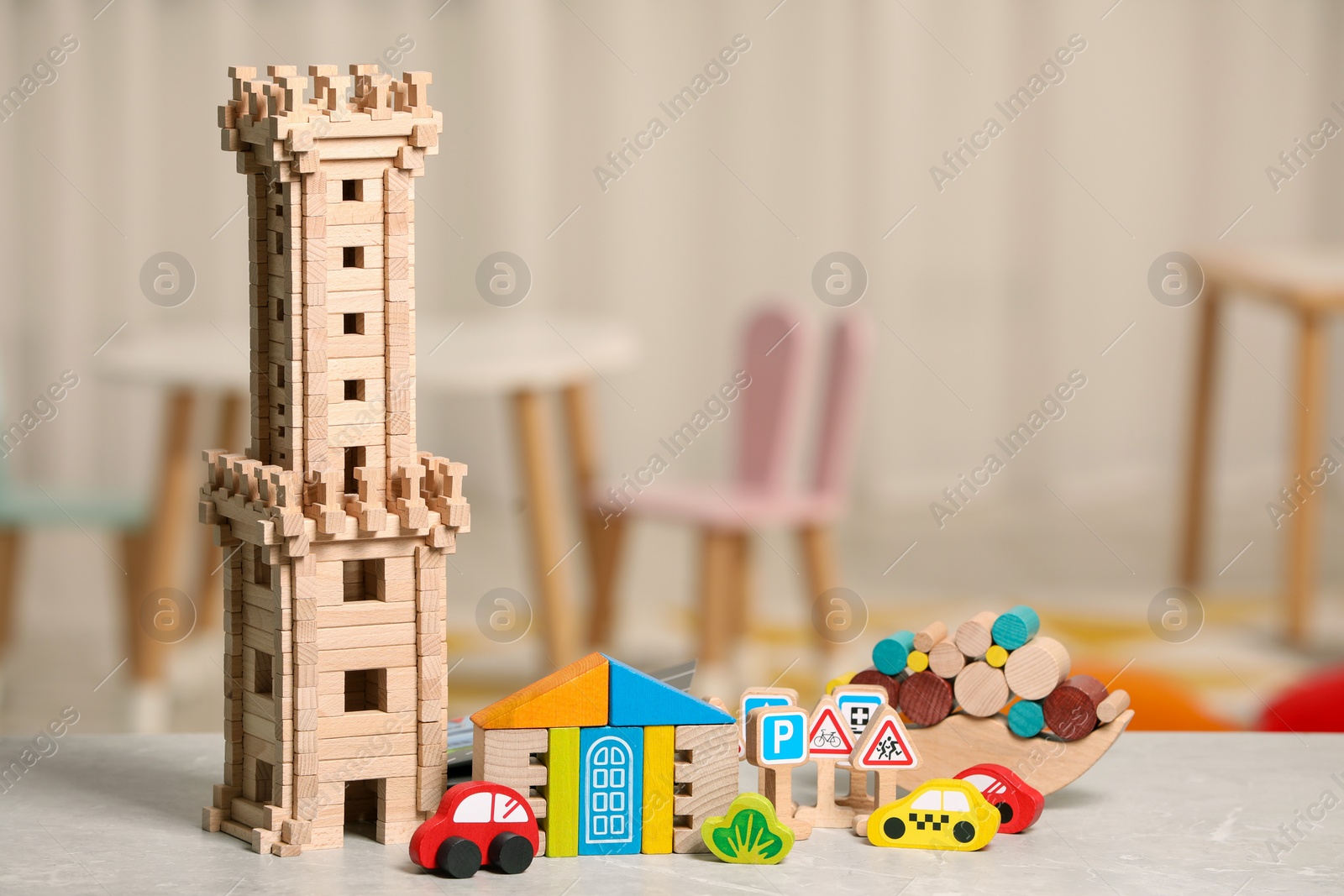 Photo of Set of wooden toys on light grey table indoors, space for text. Children's development