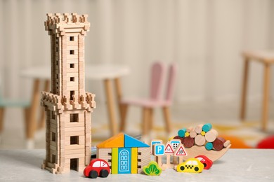 Photo of Set of wooden toys on light grey table indoors, space for text. Children's development