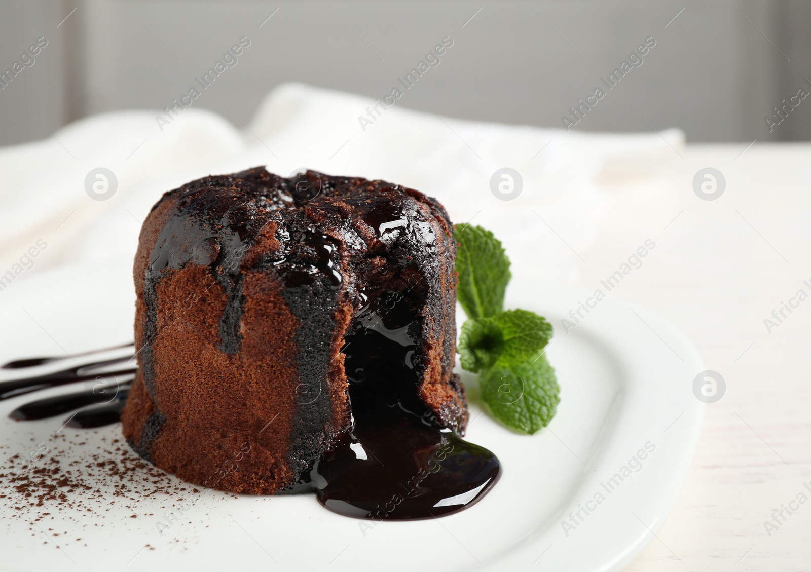 Photo of Delicious warm chocolate lava cake on plate, closeup