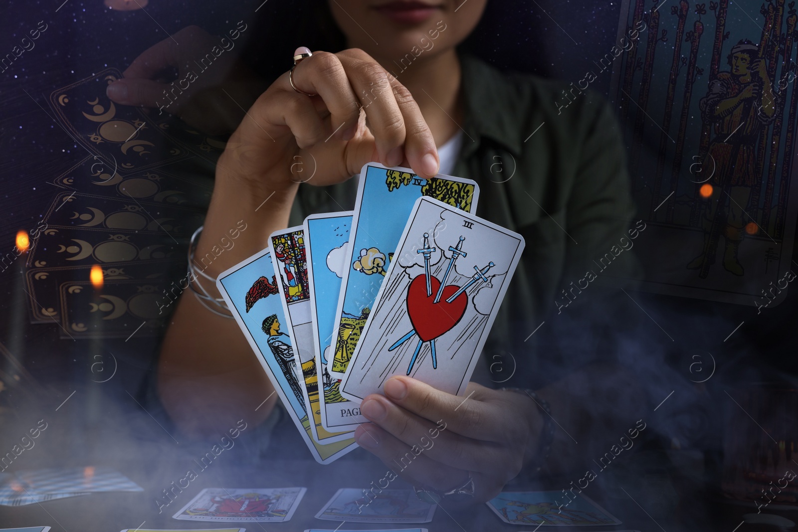 Image of Soothsayer predicting future with tarot cards at table in darkness, closeup. Double exposure