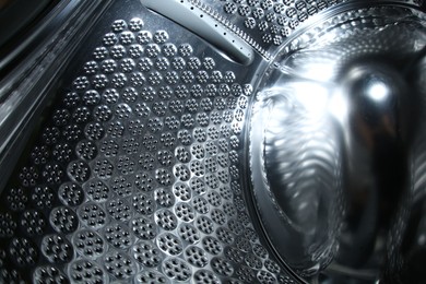Photo of Empty washing machine drum, closeup view. Laundry day