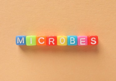 Word Microbes made with colorful cubes on color background, flat lay