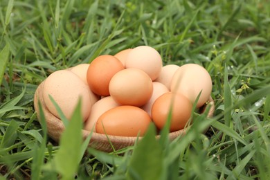 Photo of Fresh chicken eggs on green grass outdoors, closeup