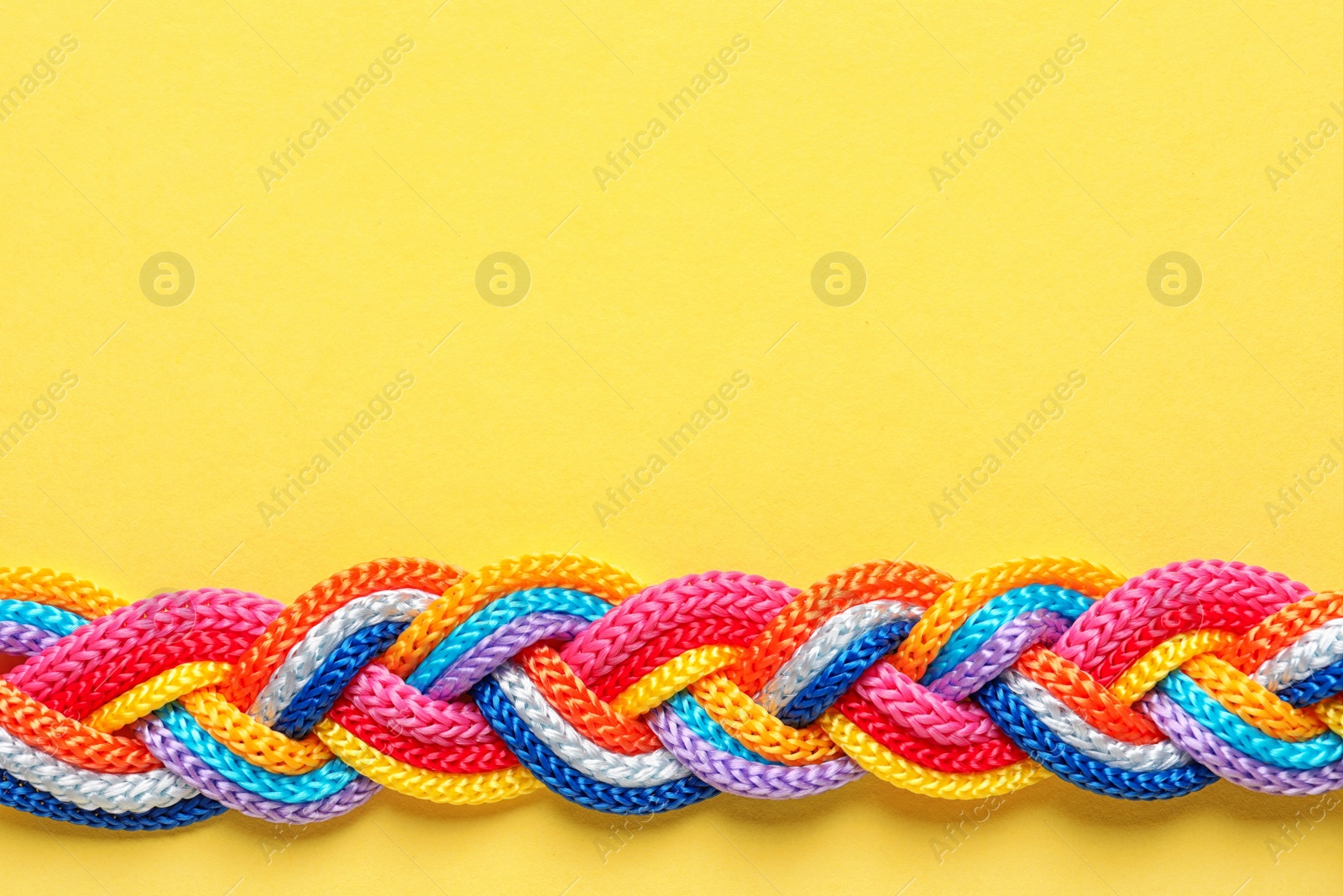 Photo of Braided ropes on color background, top view. Unity concept