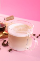 Photo of Cup of fresh coffee and beans on pink table