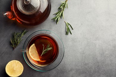 Photo of Aromatic herbal tea with rosemary and lemon on grey table, flat lay. Space for text