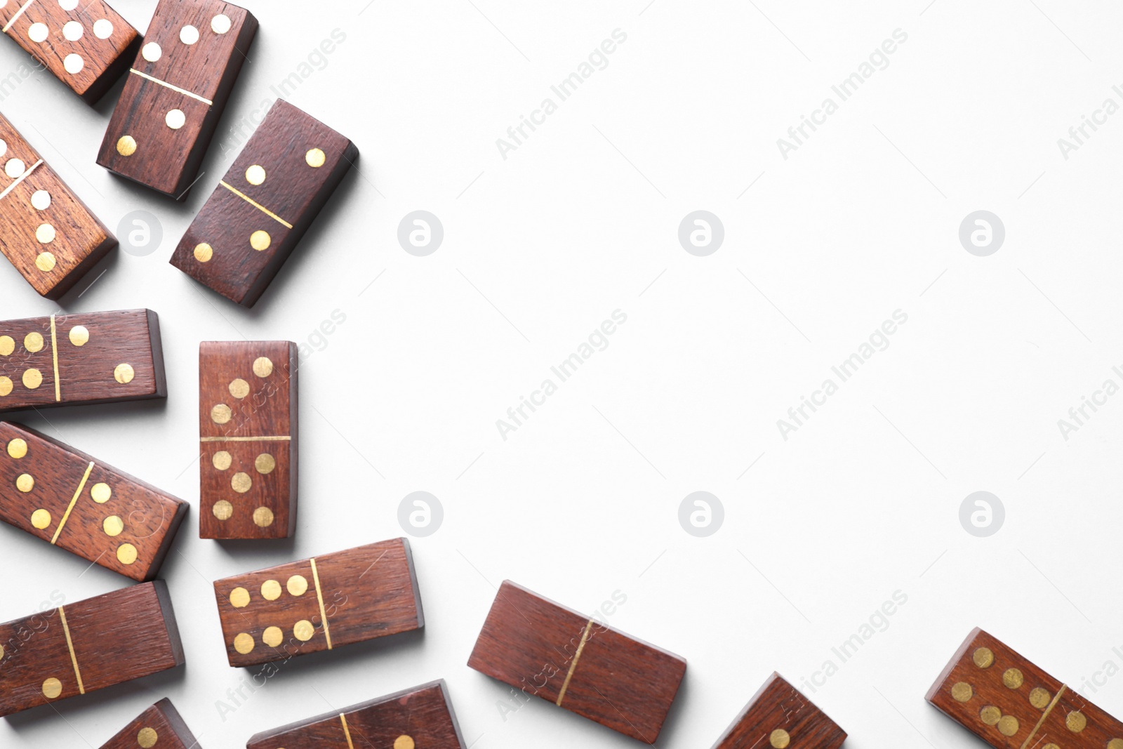 Photo of Wooden domino tiles on white background, flat lay. Space for text