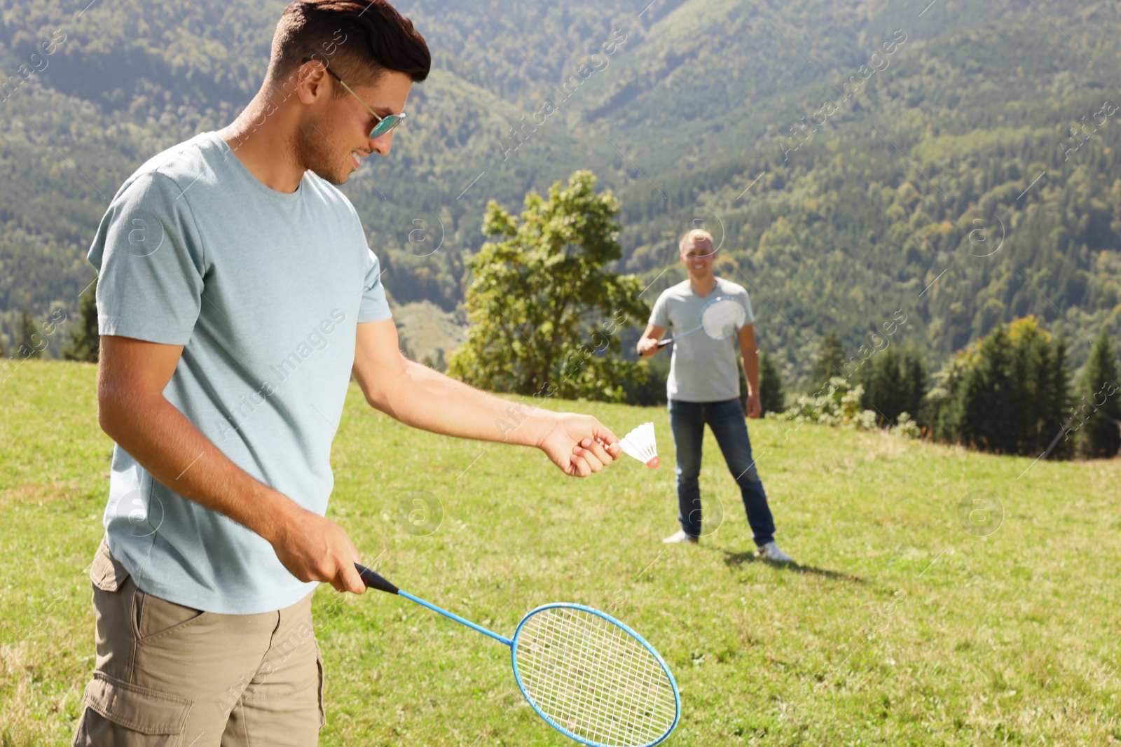 Photo of Friends playing badminton in mountains on sunny day