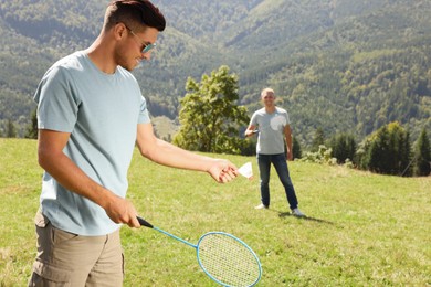 Friends playing badminton in mountains on sunny day