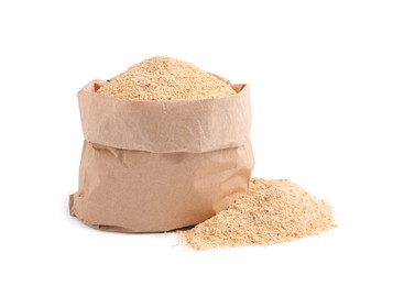Fresh bread crumbs and paper bag on white background