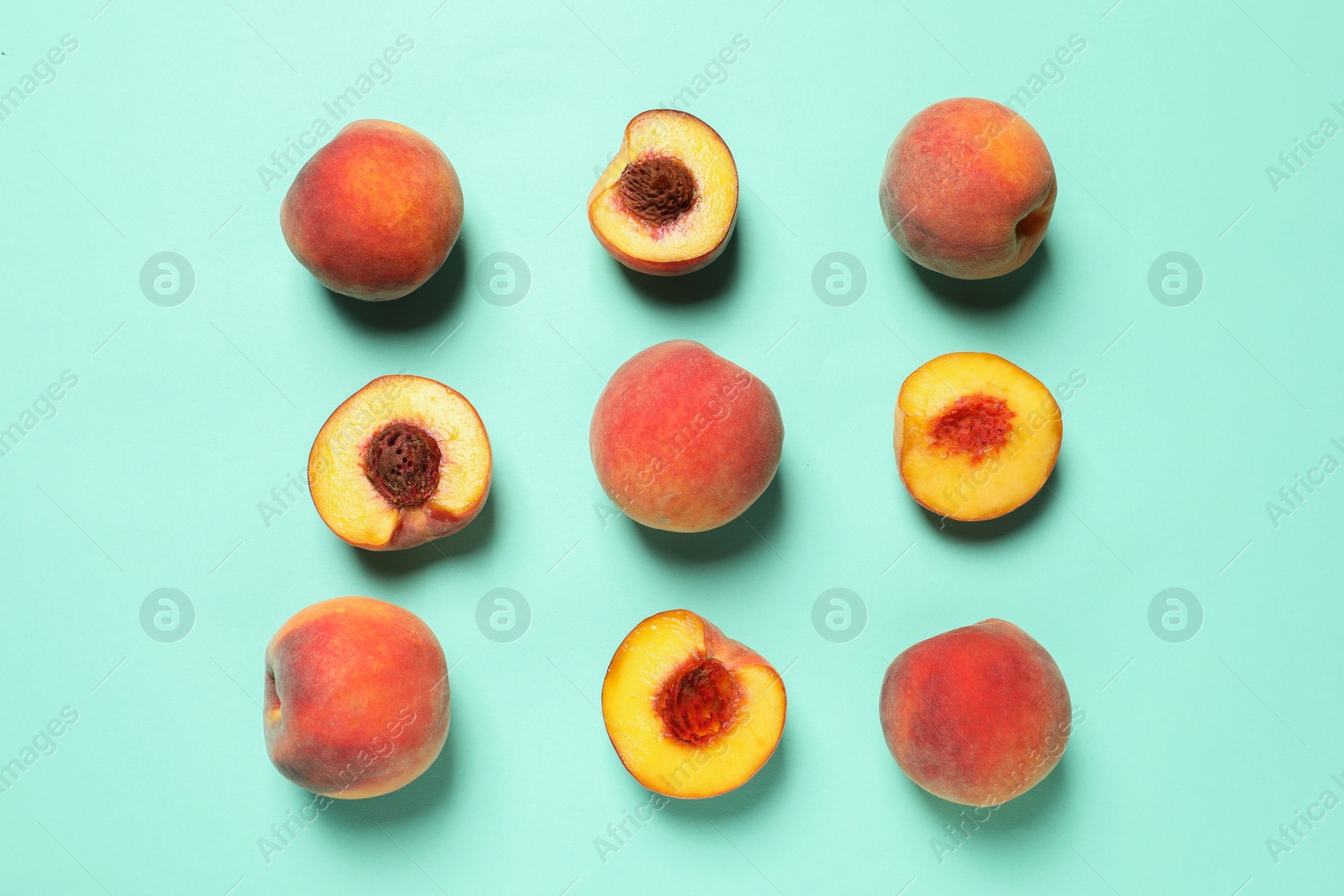 Photo of Cut and whole fresh ripe peaches on light blue background, flat lay