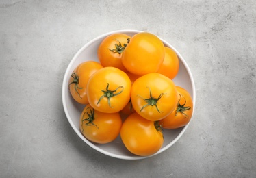 Photo of Ripe yellow tomatoes on grey table, top view