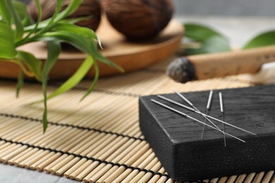 Photo of Board with needles for acupuncture on bamboo mat