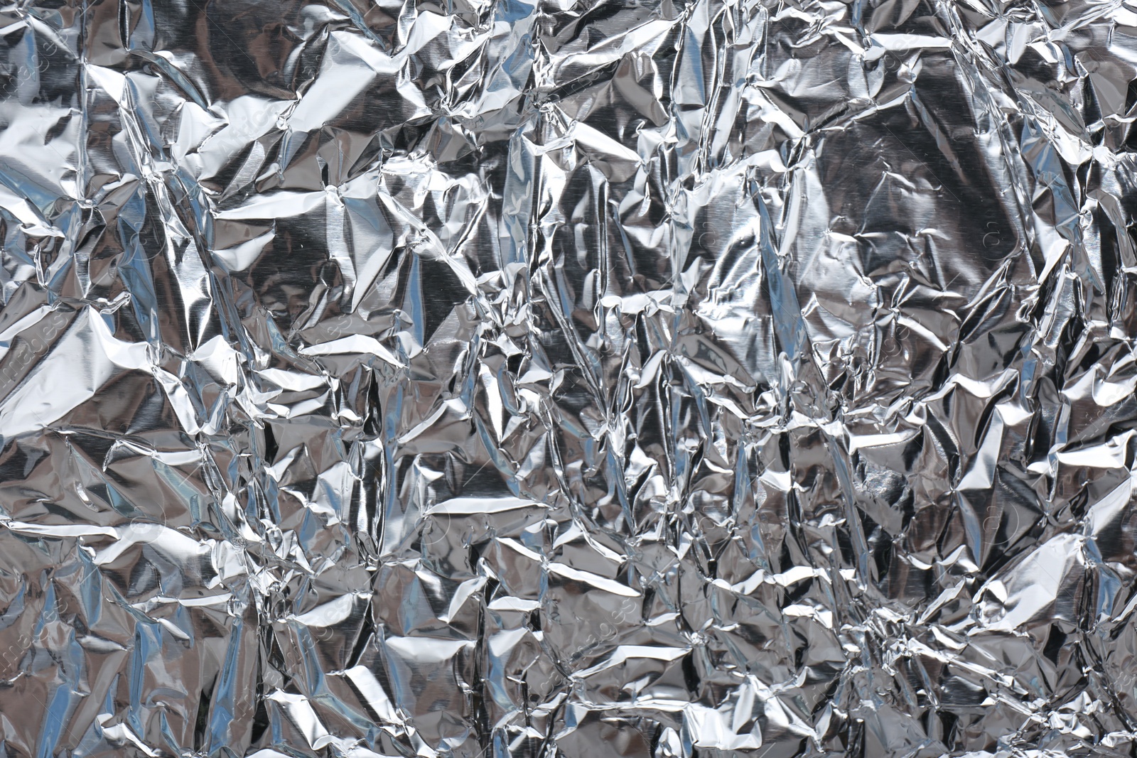 Photo of Crumpled silver foil as background, closeup view