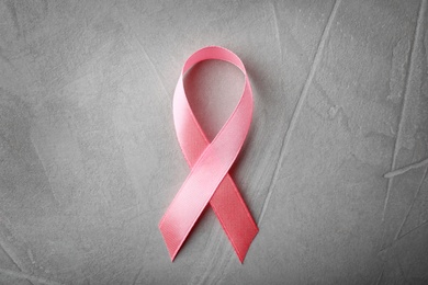 Photo of Pink ribbon on grey background, top view. Breast cancer awareness concept