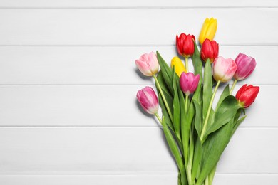 Photo of Beautiful colorful tulip flowers on white wooden table, flat lay. Space for text