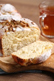 Delicious yeast dough cake and tea on wooden table, closeup