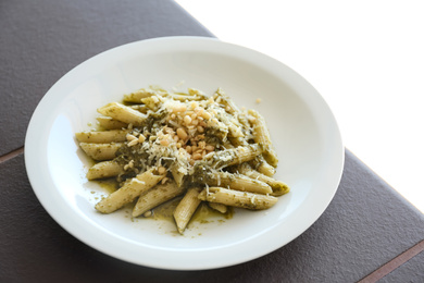 Photo of Delicious penne pasta with pesto sauce on plate