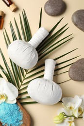 Photo of Flat lay composition with herbal massage bags and other spa products on beige background