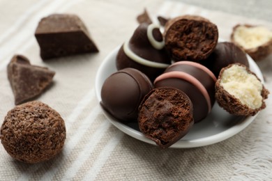 Photo of Many different delicious chocolate truffles on kitchen towel