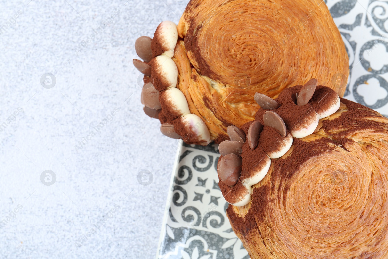 Photo of Tasty puff pastry. Supreme croissants with chocolate chips and cream on grey table, above view. Space for text