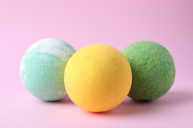 Photo of Colorful bath bombs on pink background, closeup