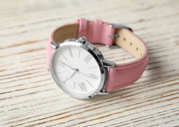 Stylish wrist watch on wooden table. Fashion accessory
