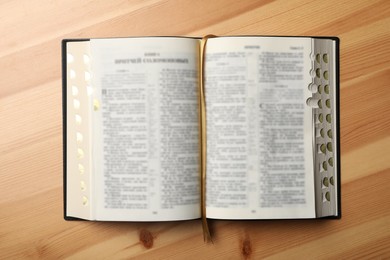 Photo of Open Bible on wooden table, top view