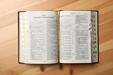 Open Bible on wooden table, top view