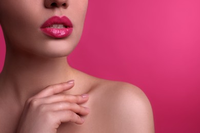 Closeup view of woman with beautiful full lips on pink background, space for text