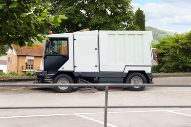 Modern sweeping car on road in city