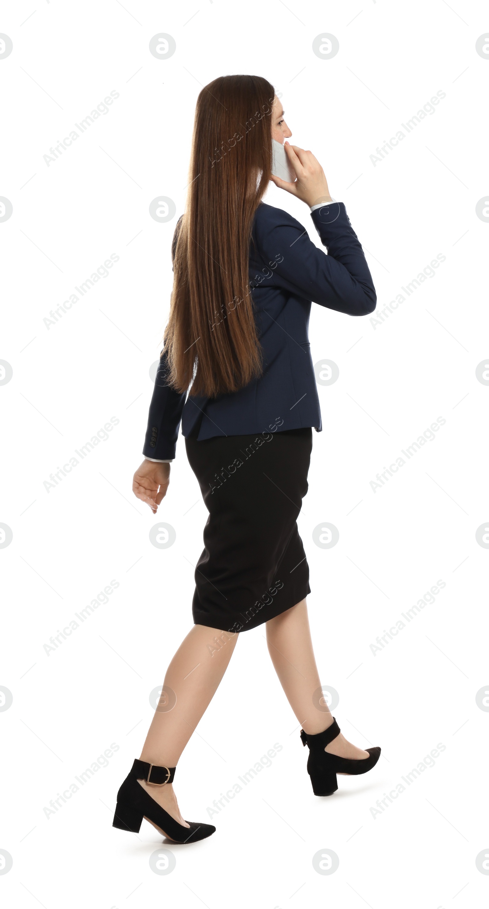 Photo of Young businesswoman talking on smartphone while walking against white background