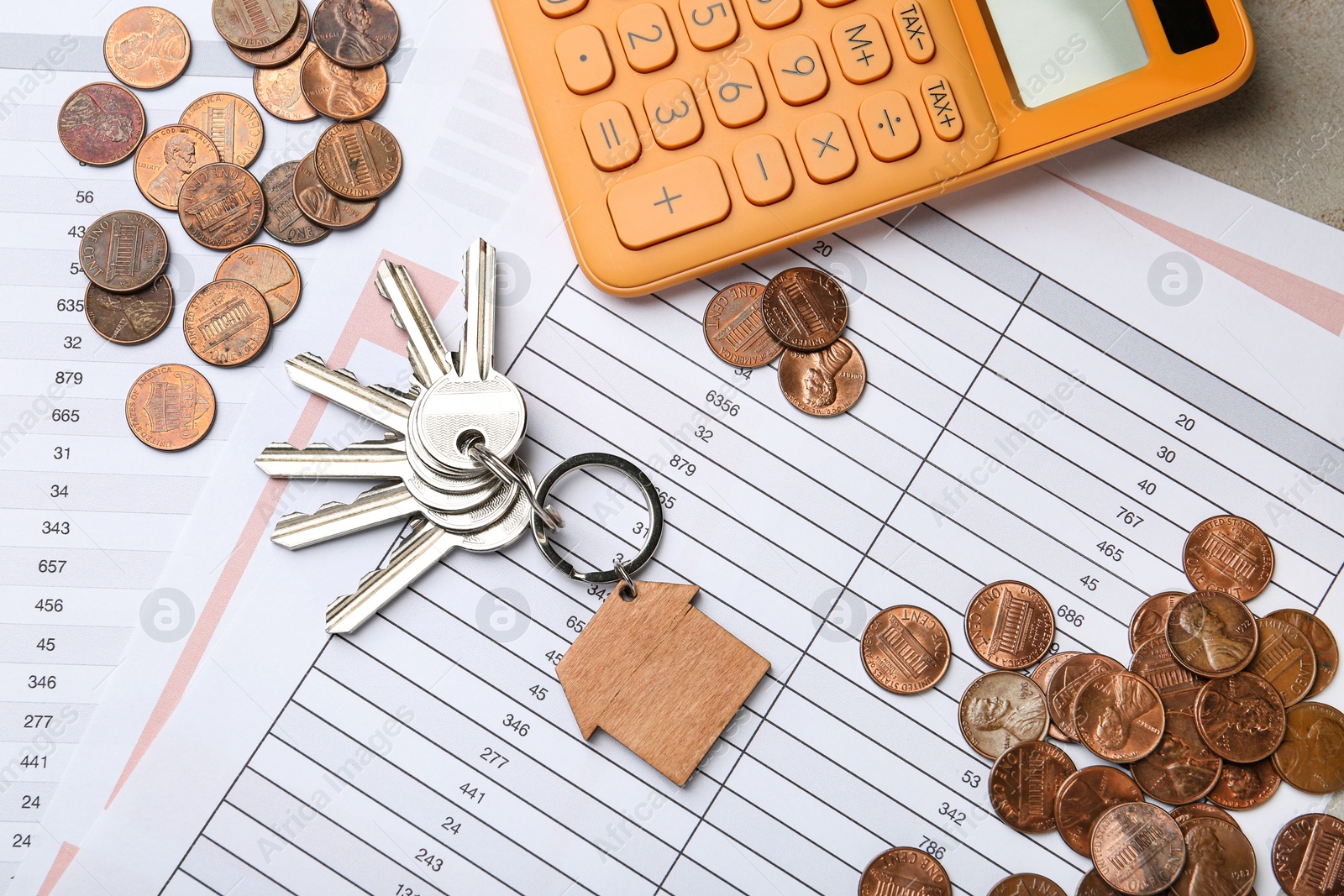 Photo of Calculator with documents, keys and coins on table, top view. Real estate agent service