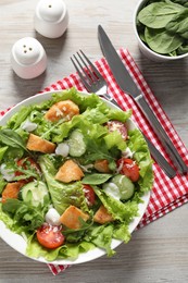Photo of Delicious salad with chicken and vegetables served on wooden table, flat lay