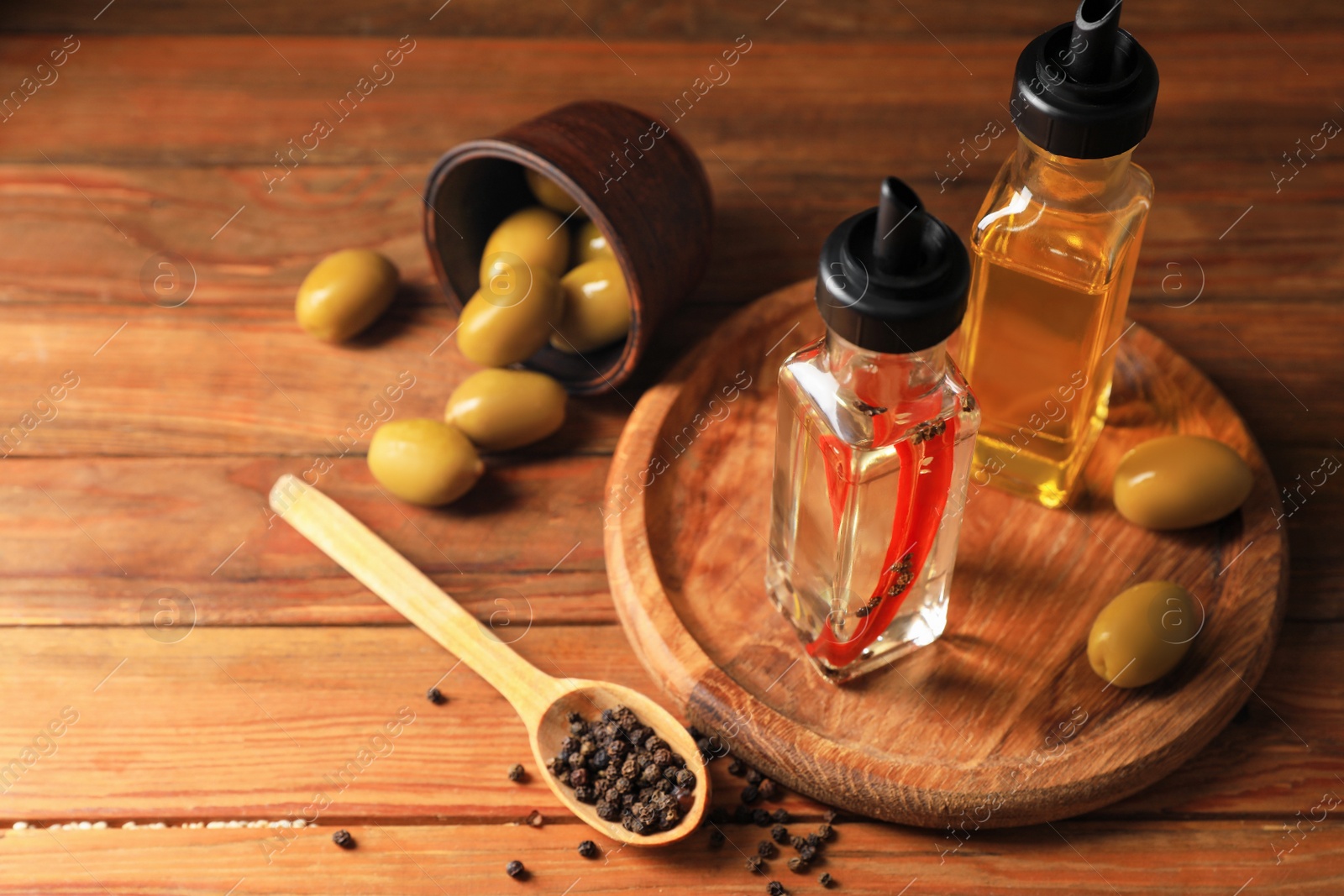 Photo of Different cooking oils and ingredients on wooden table