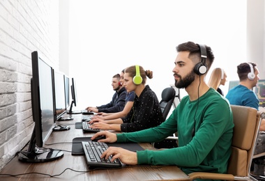 Young people playing video games on computers indoors. Esports tournament