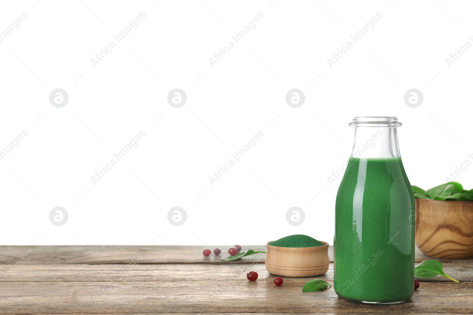 Photo of Bottle of spirulina smoothie and bowl with powder on table against white background. Space for text