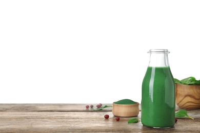 Bottle of spirulina smoothie and bowl with powder on table against white background. Space for text