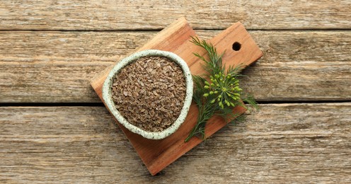 Image of Dill seeds in bowl on wooden table, top view. Banner design