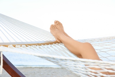 Young woman resting in hammock at seaside. Summer vacation