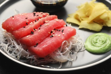 Photo of Tasty sashimi (pieces of fresh raw tuna) and glass noodles on plate, closeup