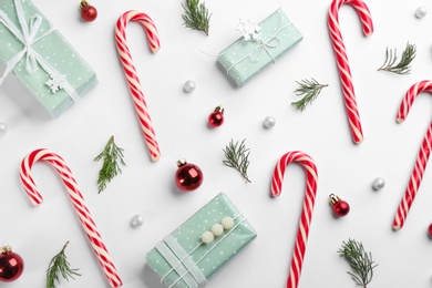 Flat lay composition with candy canes and Christmas decor on white background