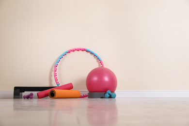 Photo of Different sports equipment near light wall in gym