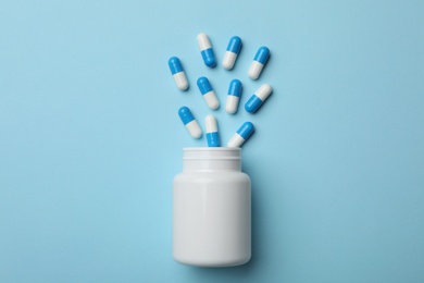 Bottle with pills on color background, flat lay