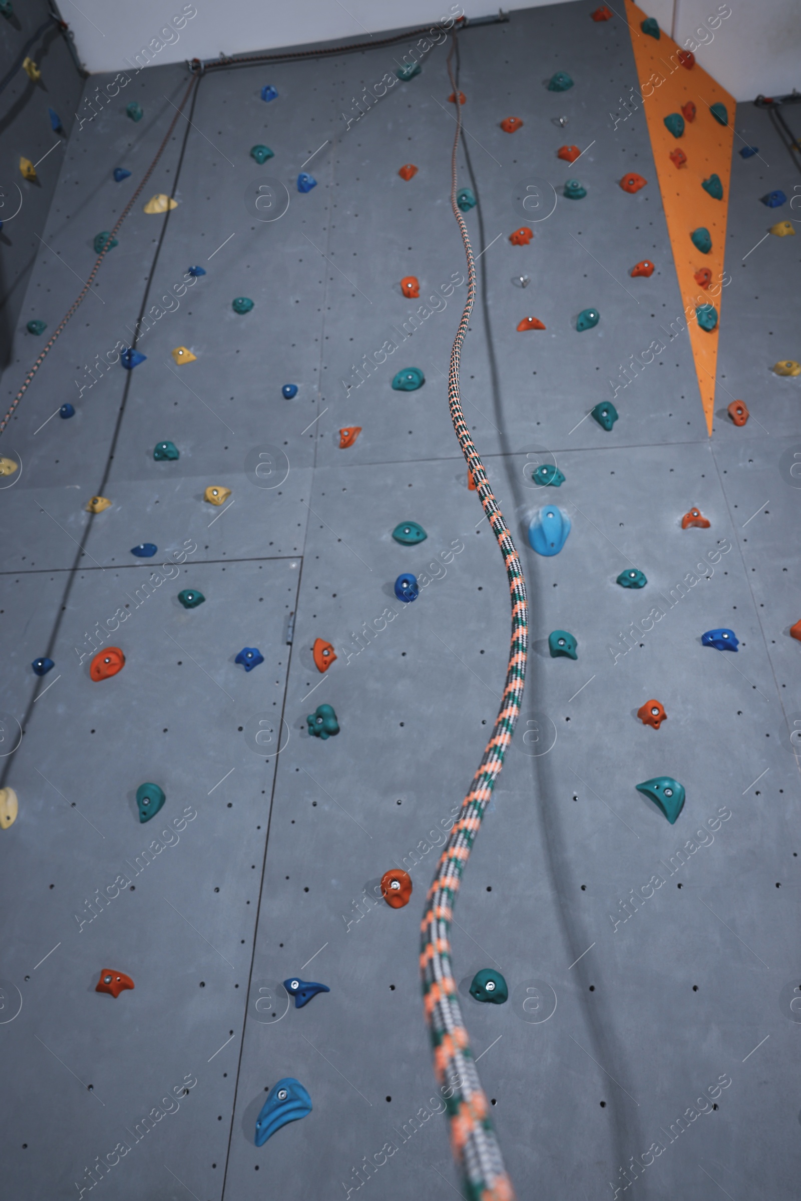 Photo of Climbing wall with holds and ropes in gym. Extreme sport