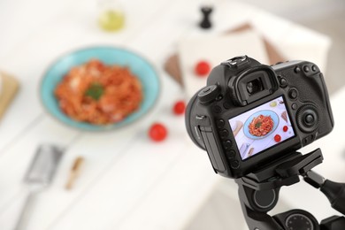 Photo of Professional camera with picture of spaghetti on display in studio, space for text. Food stylist