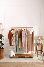 Photo of Stylish clothes hanging on rack in dressing room. Interior design