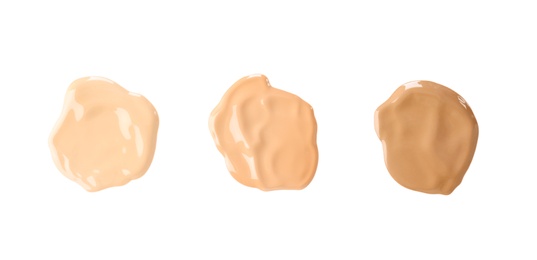 Photo of Samples of different foundation shades on white background, top view