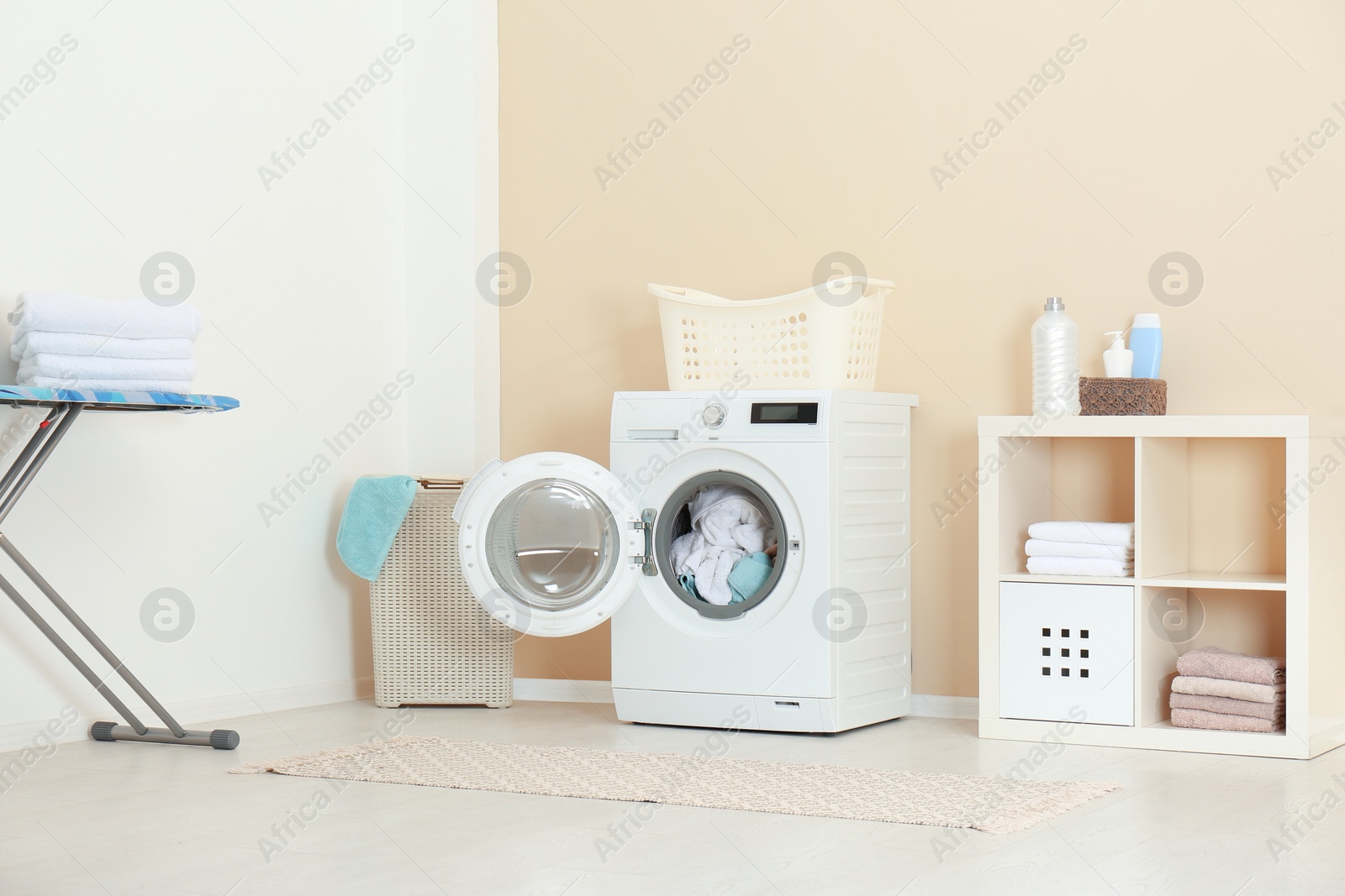 Photo of Crumpled towels in washing machine at home. Laundry room interior