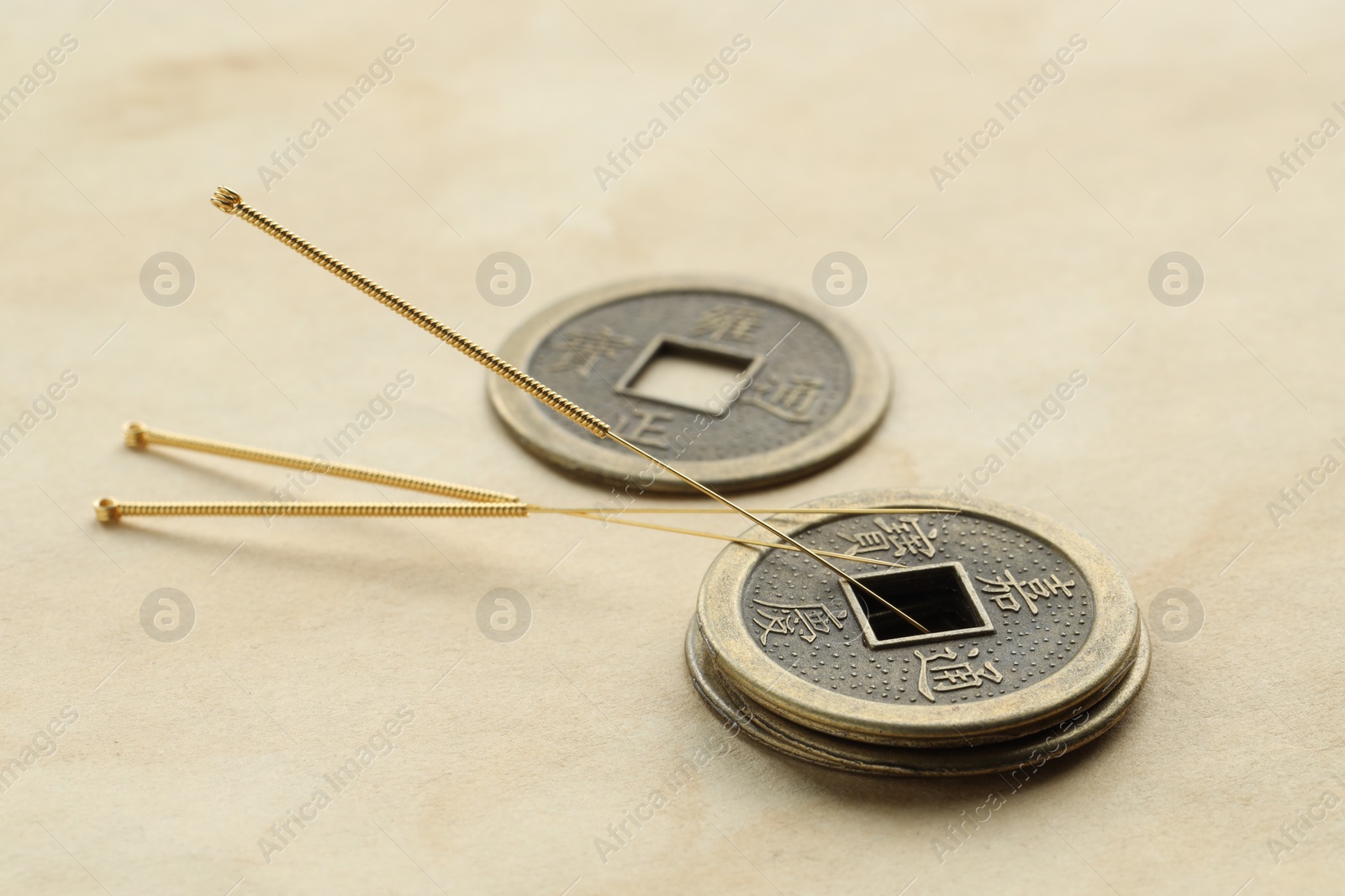 Photo of Acupuncture needles and Chinese coins on paper, closeup